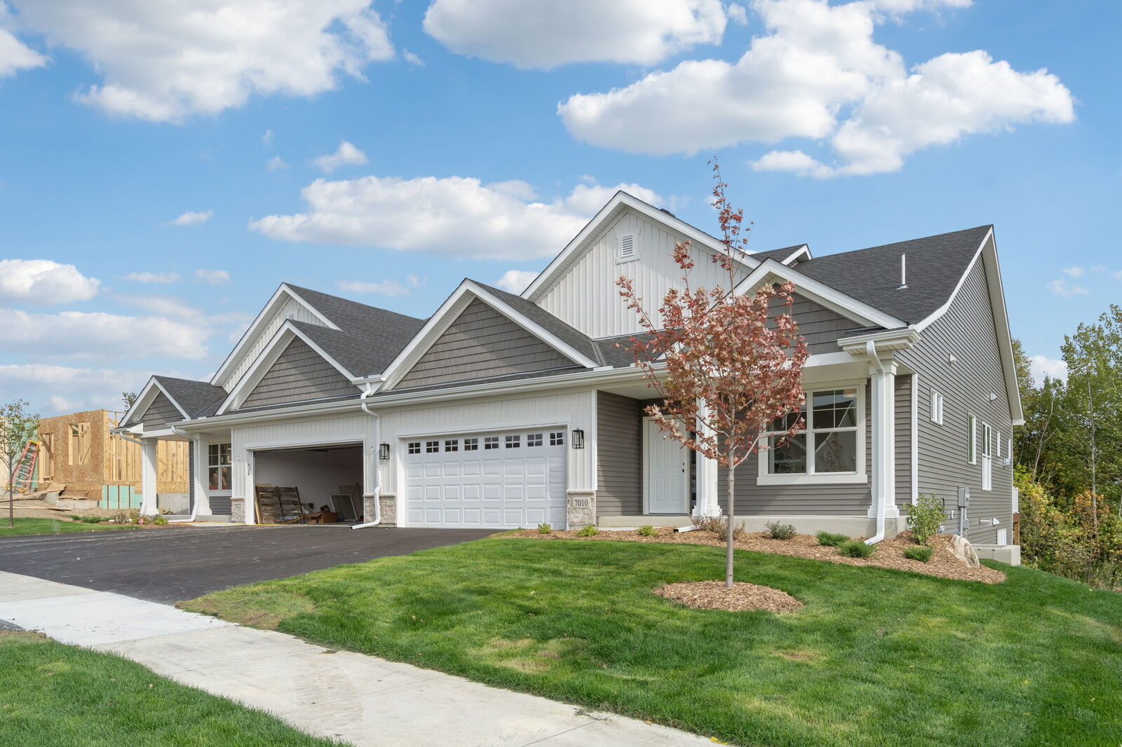 Donnay Homes twin home at Fox Briar Ridge East on a sunny day, with a young tree and green lawn
